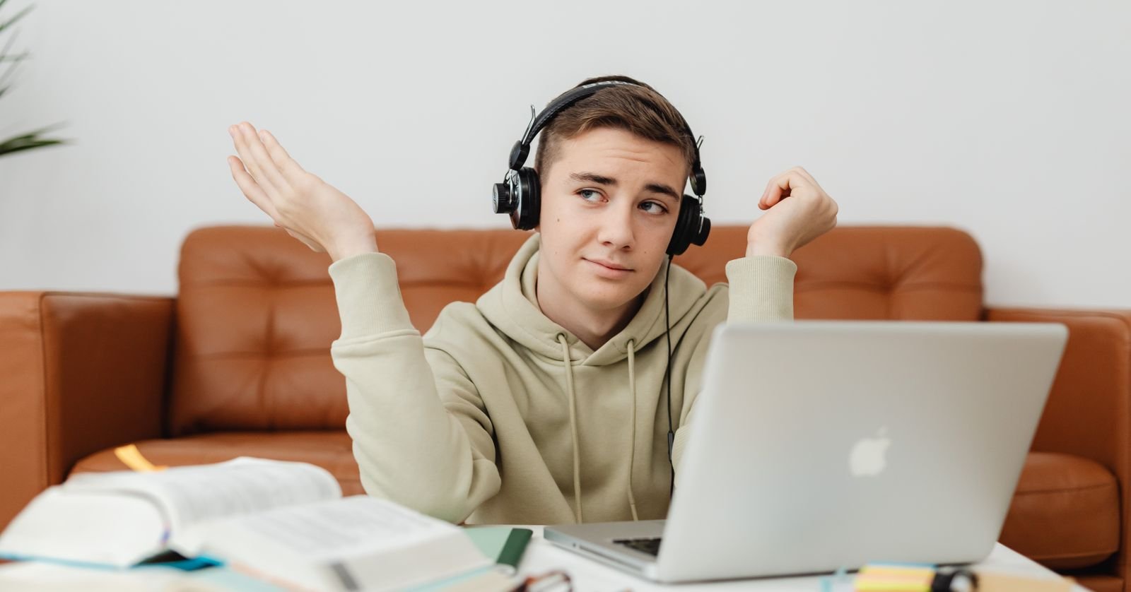 Someone watching a recorded talk on a laptop, wearing headphones.