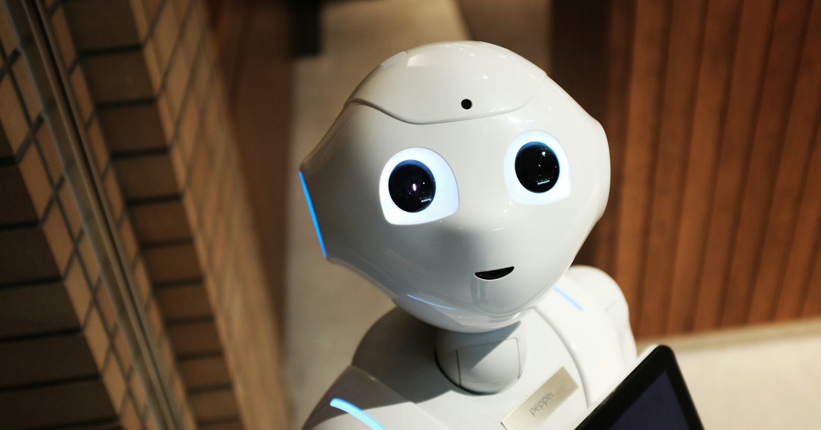 A robot facing a screen, for the question of whether AI can really watch a video.