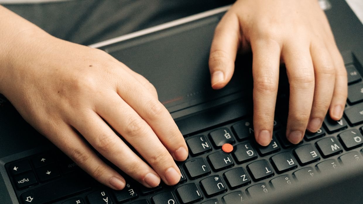 Hands typing on a keyboard.