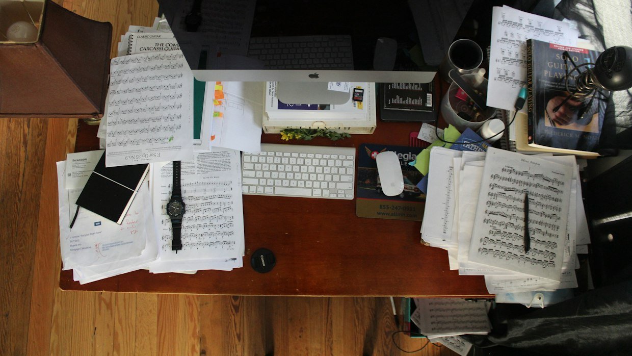 A desk covered with open books and papers.