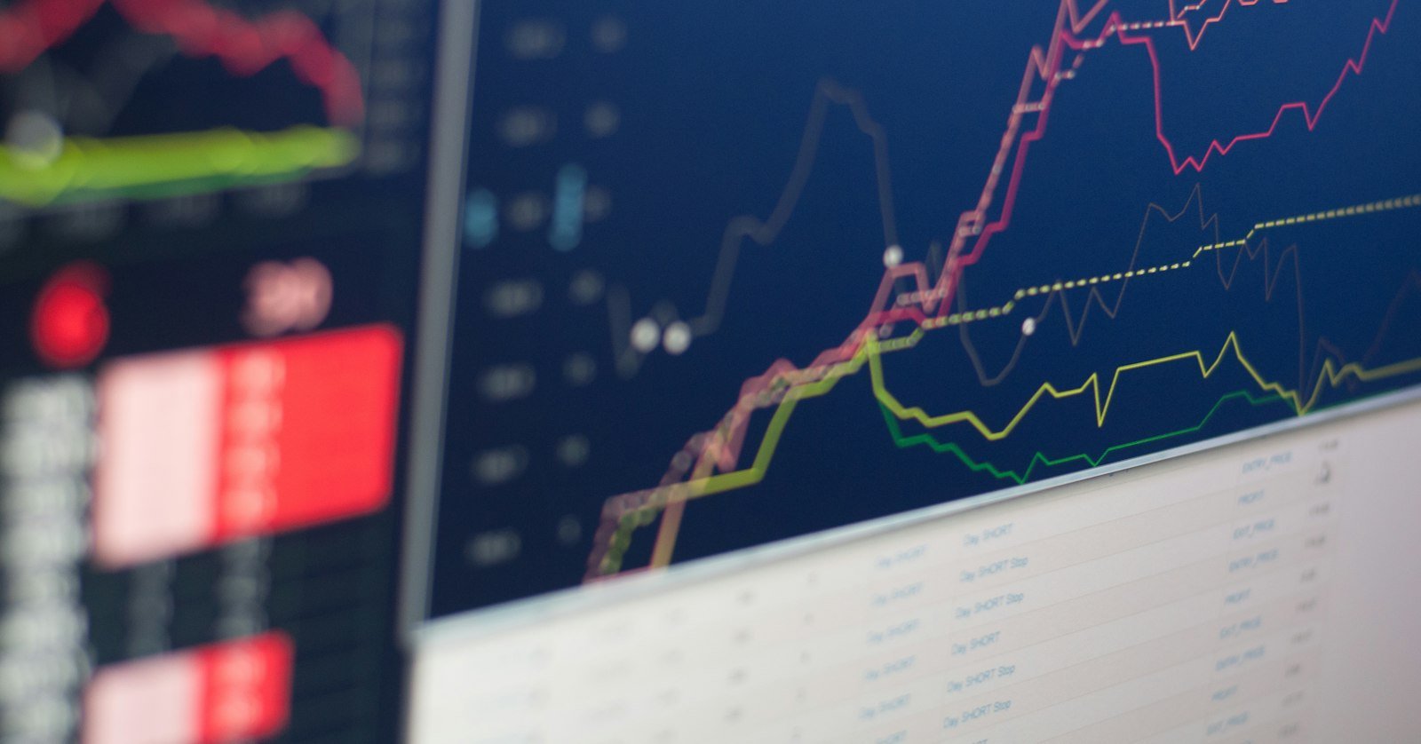 Printed financial charts spread on a desk.
