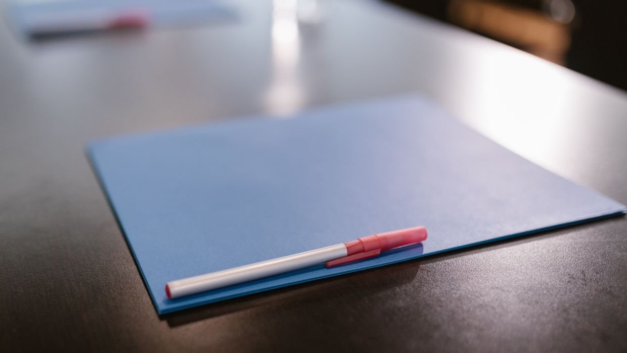 A closed folder resting on an office desk.