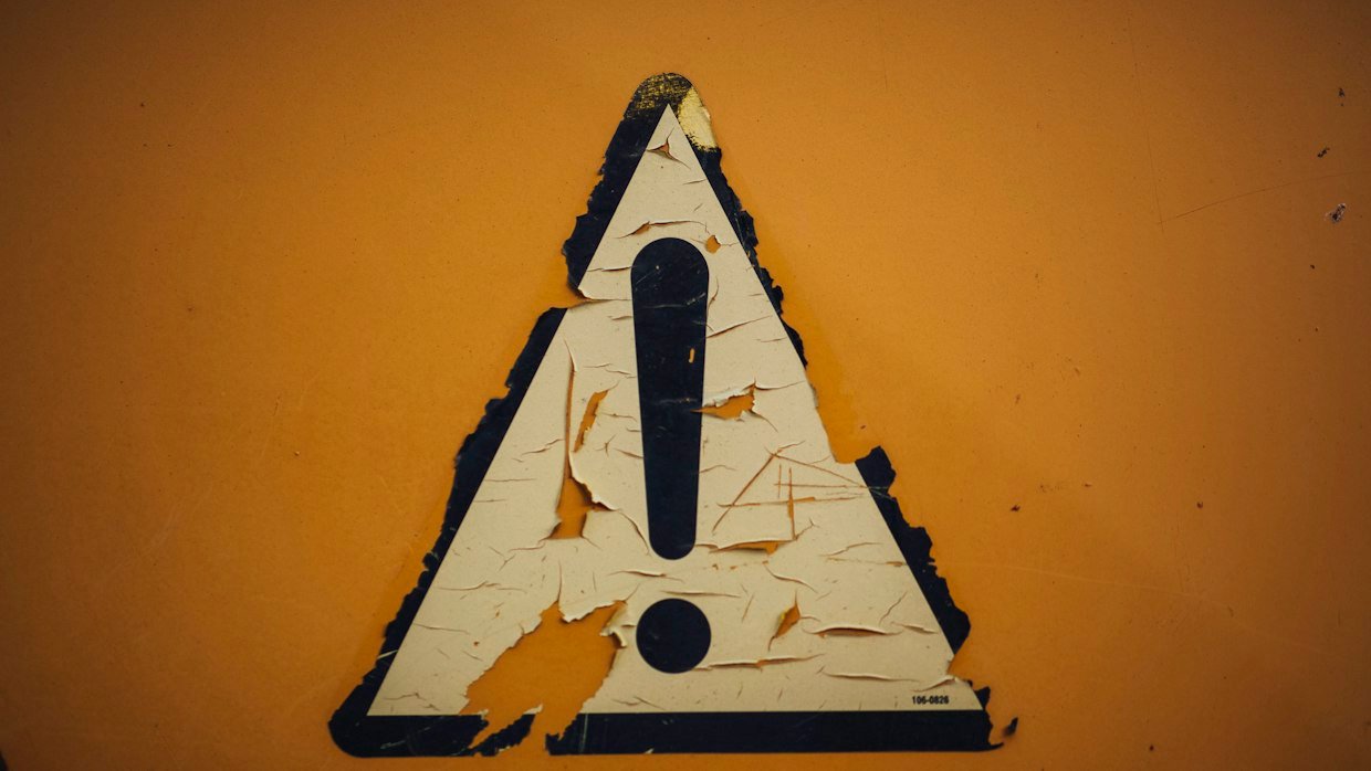 A warning triangle sign on a wall.