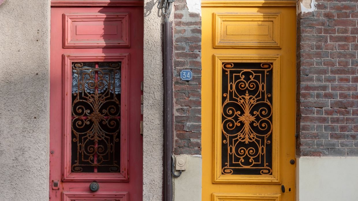 Two doors side by side along a corridor.