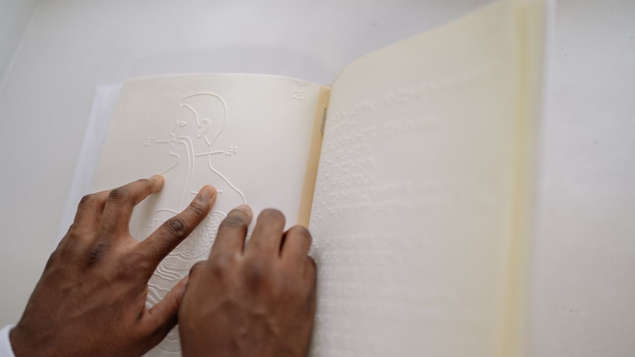 A finger holding a place in a book.