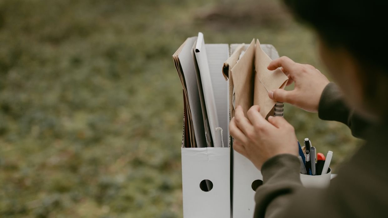 Papers being sorted into two piles on a desk.