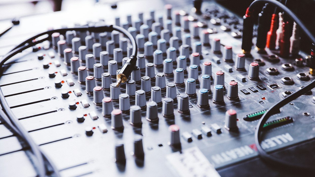 Headphones resting on a mixing desk.