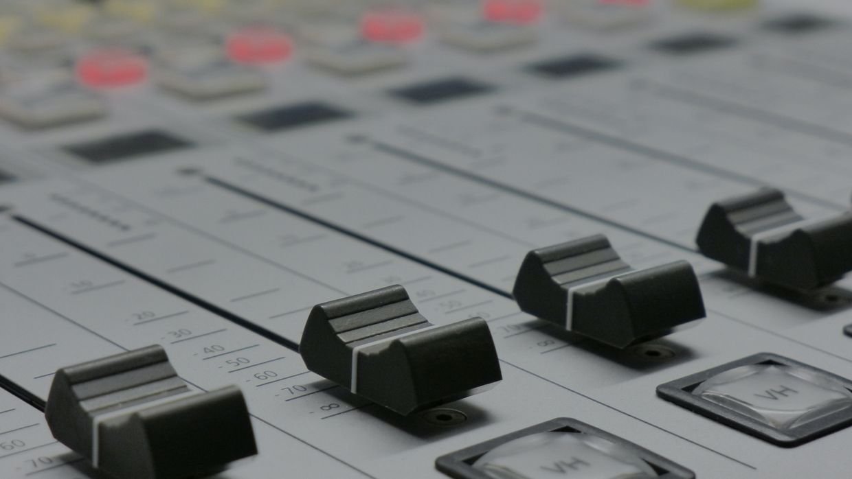 Faders on an audio mixing desk.