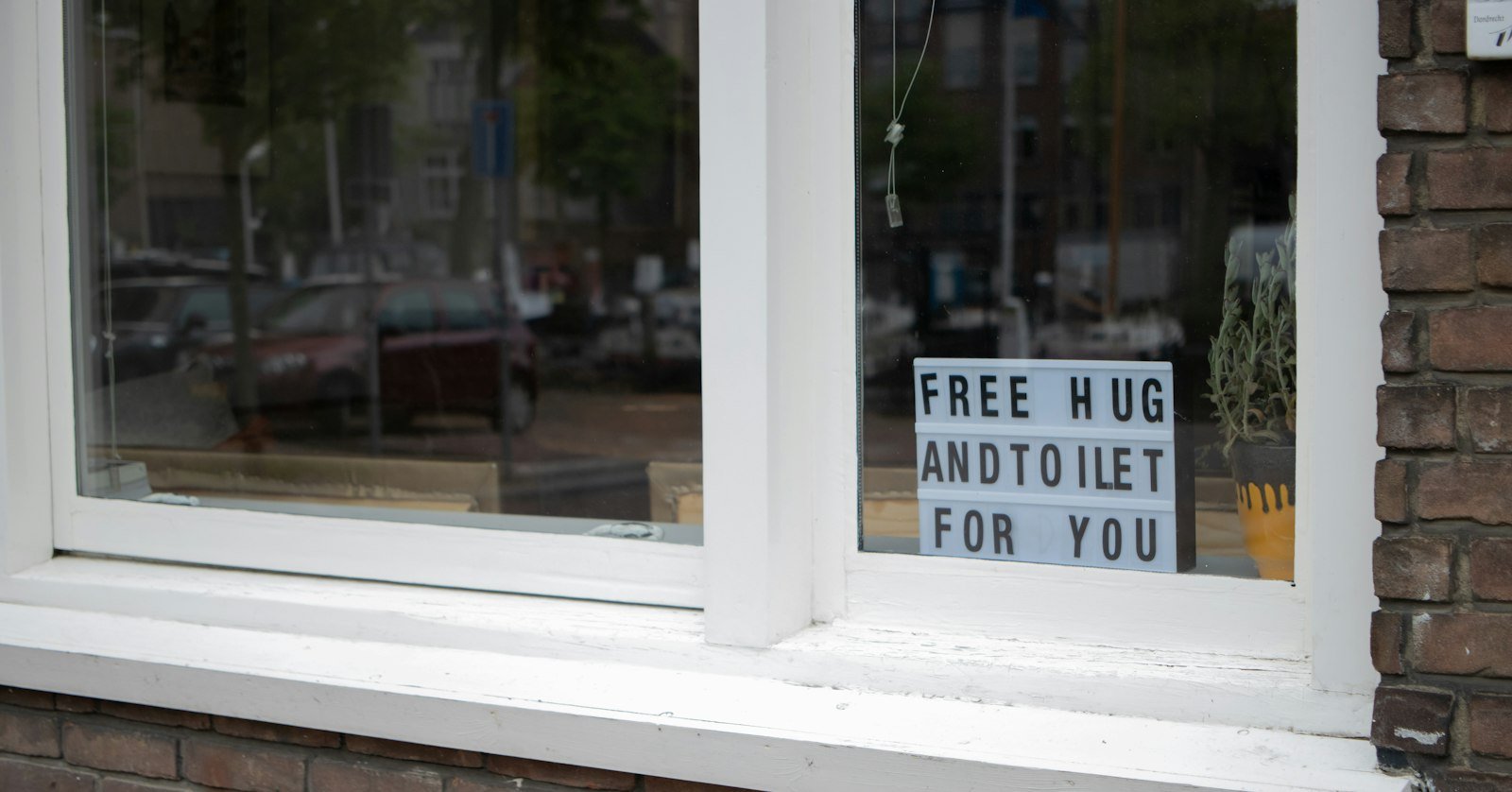 A hand-lettered sign hanging in a window.