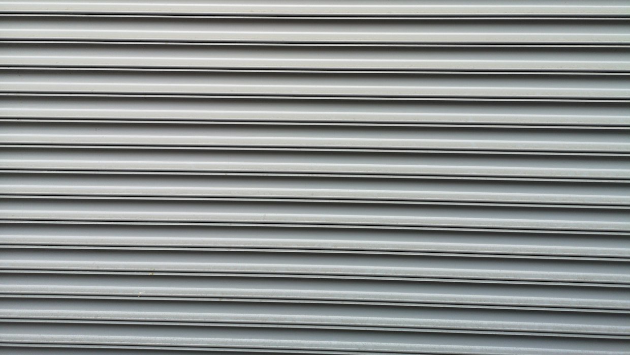A closed metal shutter on a shopfront.