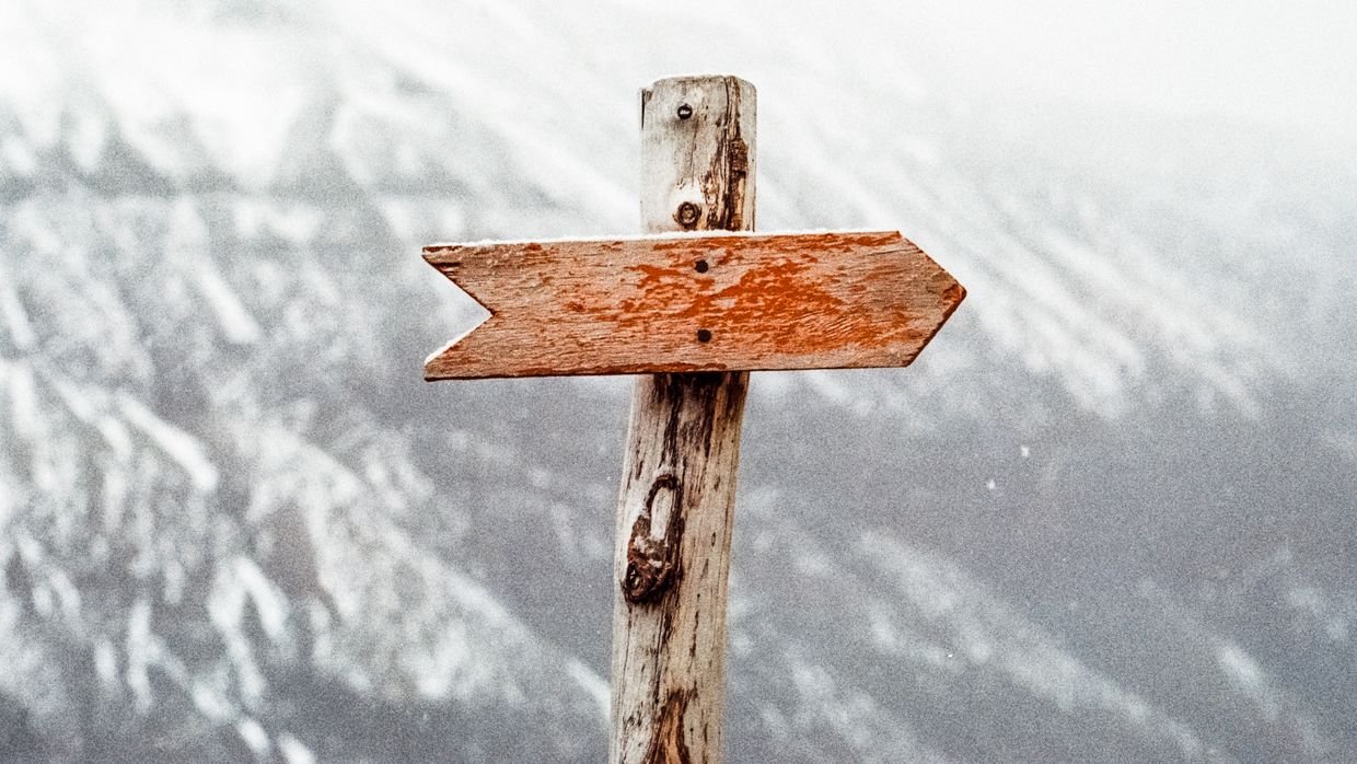 A wooden signpost pointing in two directions.