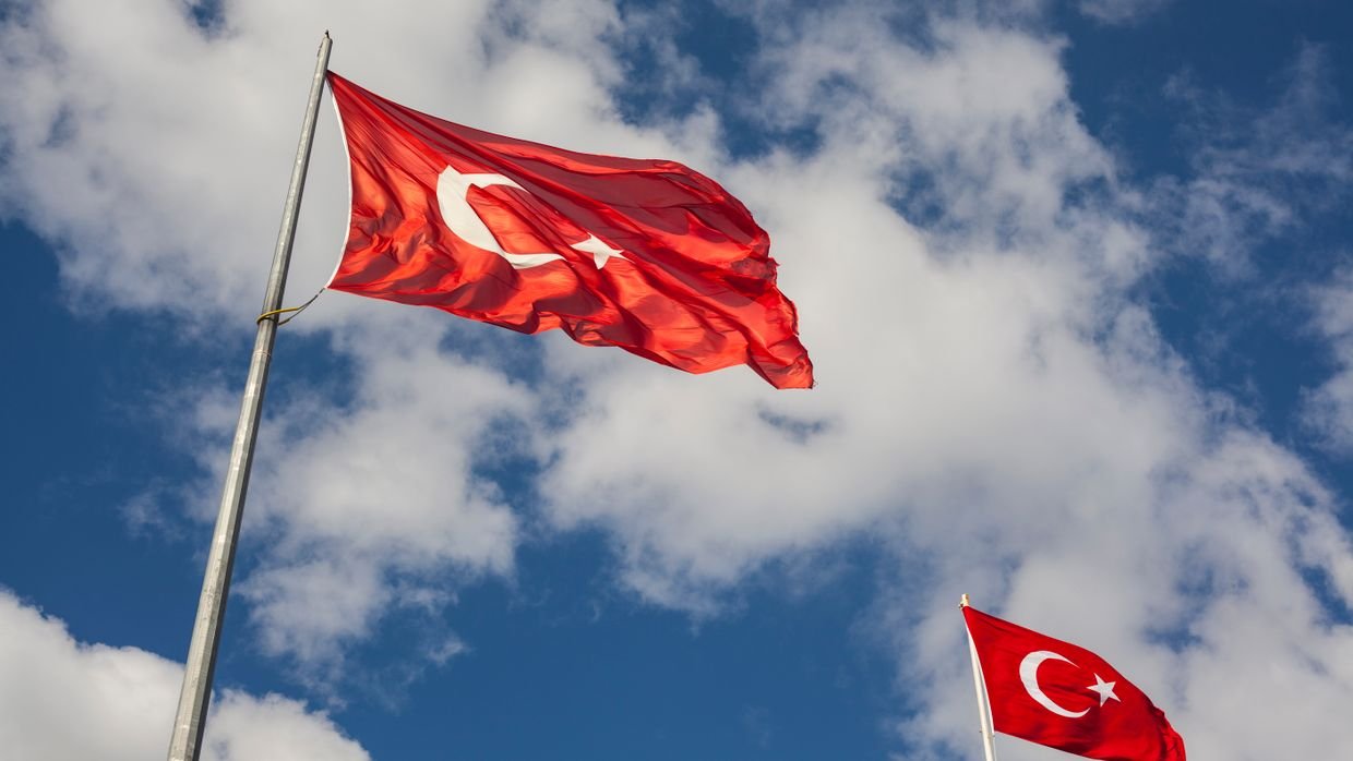 A single red flag against an open sky.