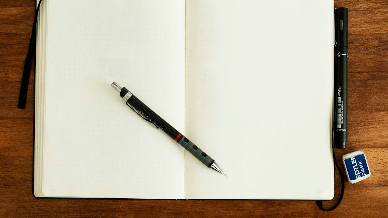 A hand writing on the first blank page of a notebook.