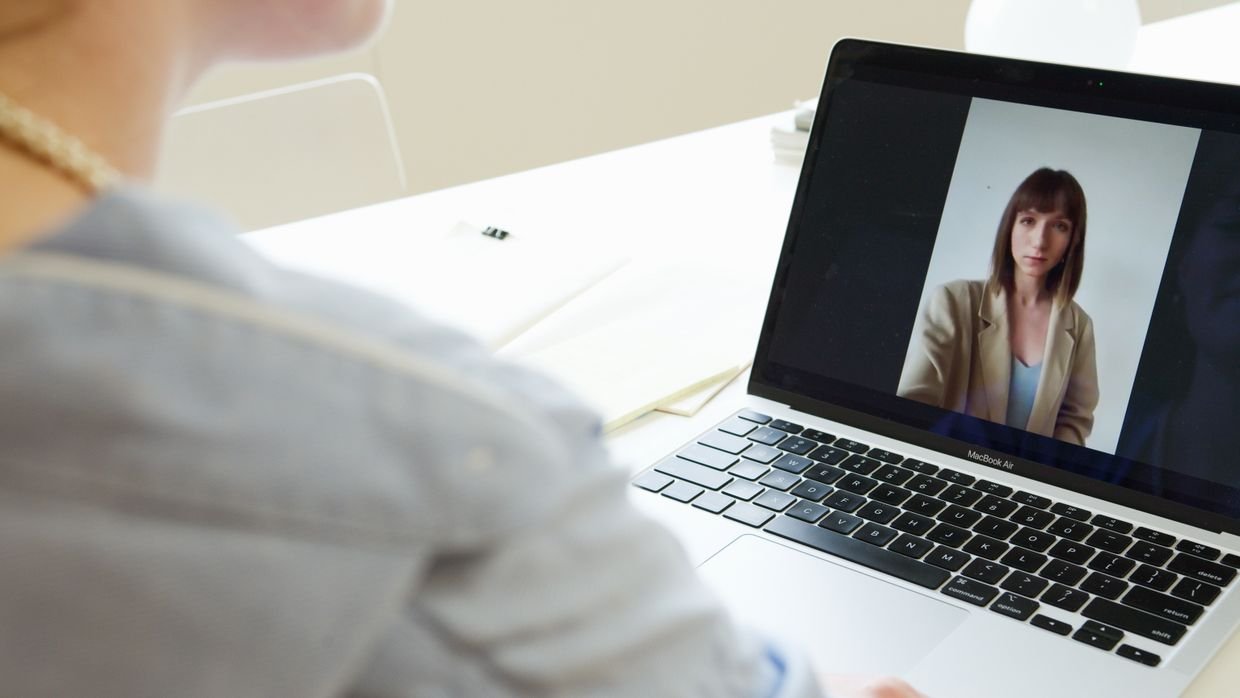 A laptop with a video and a text panel side by side, like an assistant open beside a page.