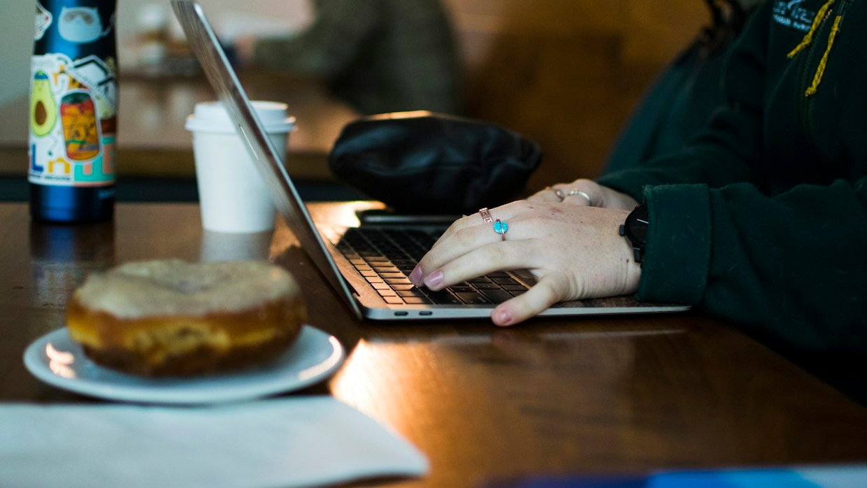 A person reading text on a laptop, for a summarizer that reads only the caption track.