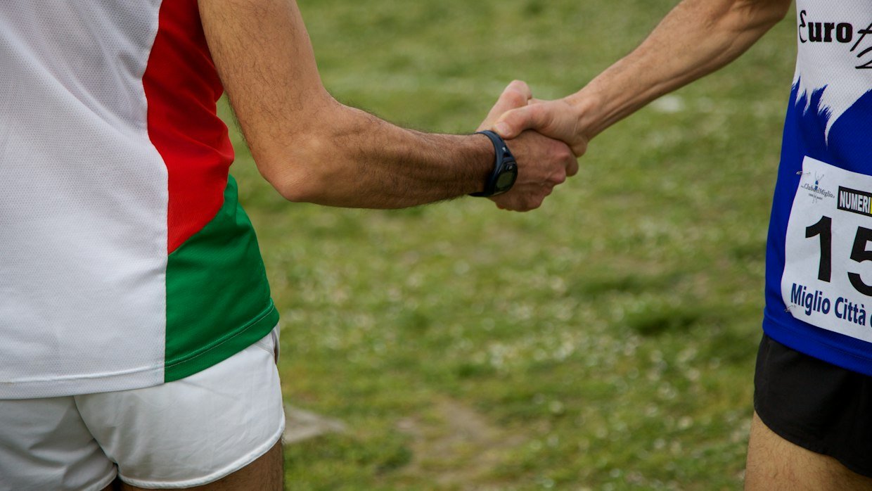 A baton passing between two runners.