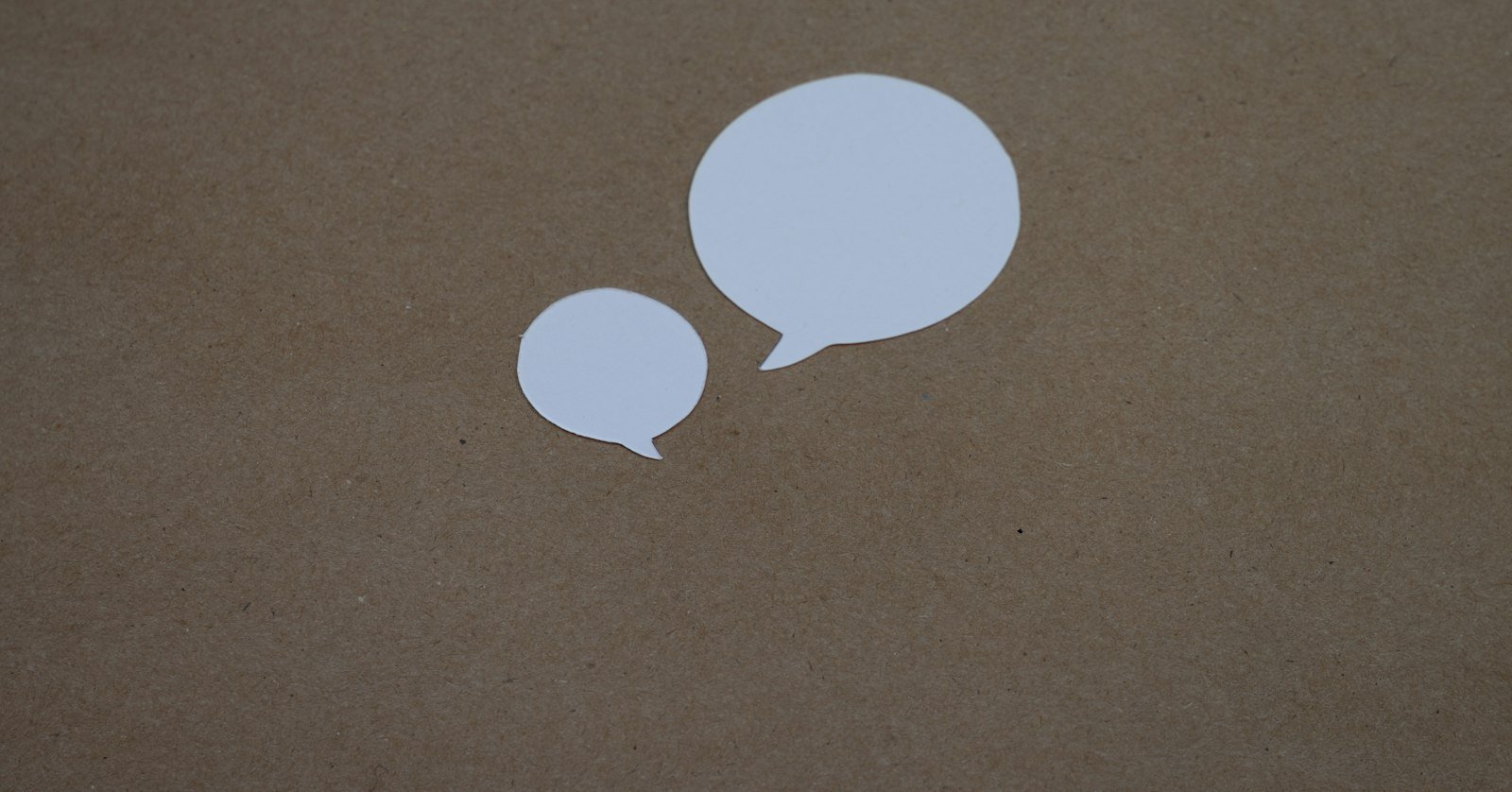 Two speech bubbles cut from paper.