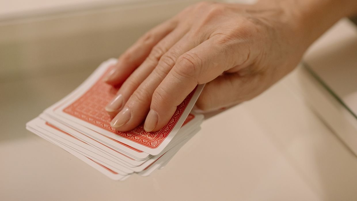 A hand selecting one card from several.