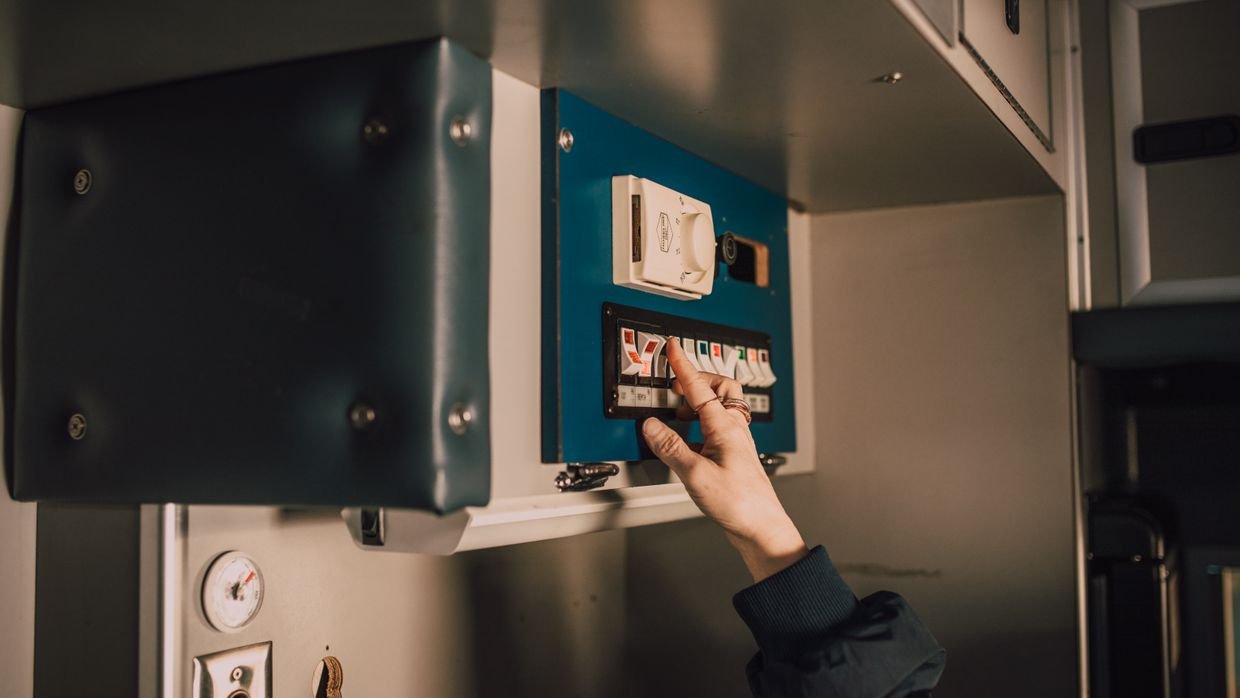 A hand reaching for a light switch.