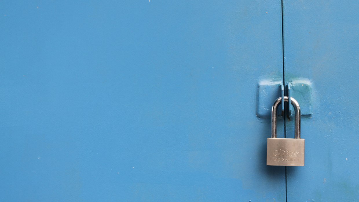 A padlock securing a metal gate.