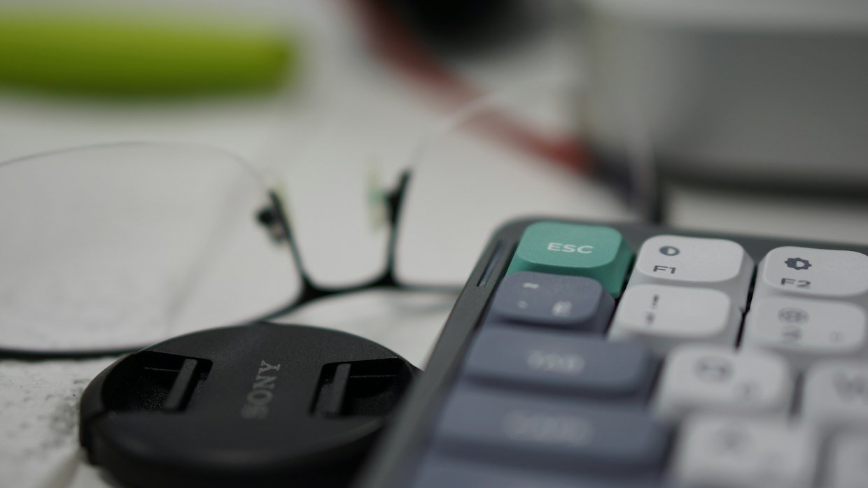 A magnifying glass held above a keyboard.