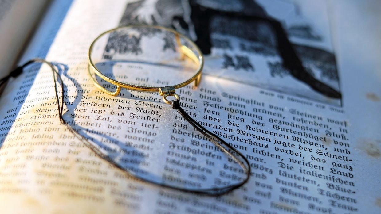 A magnifying glass over printed text, for checking a quoted line against the transcript.