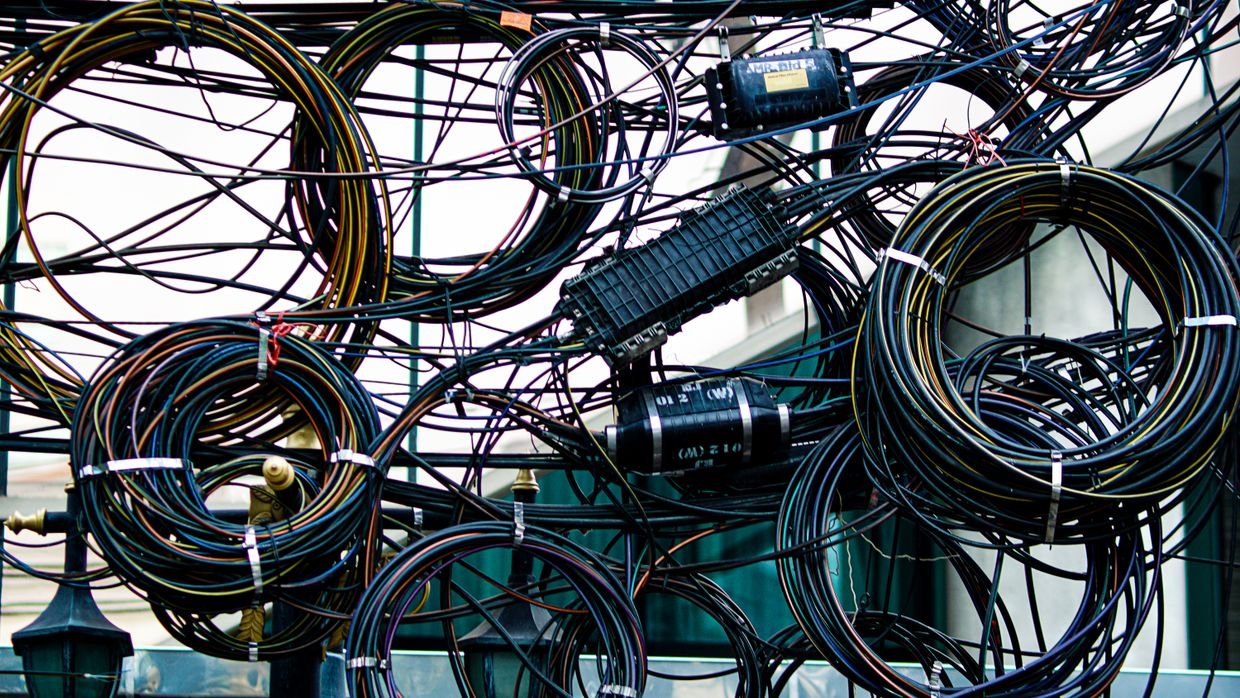 Tangled cables behind a desk.