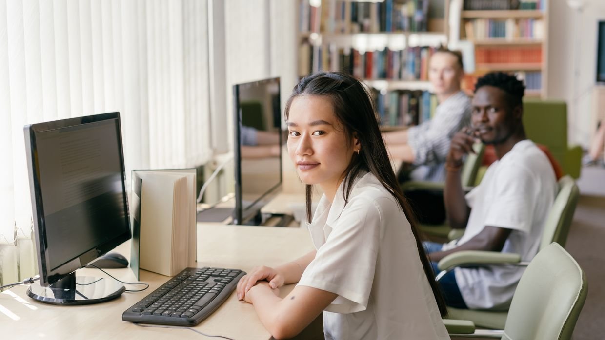 A student working alone at a library desk.