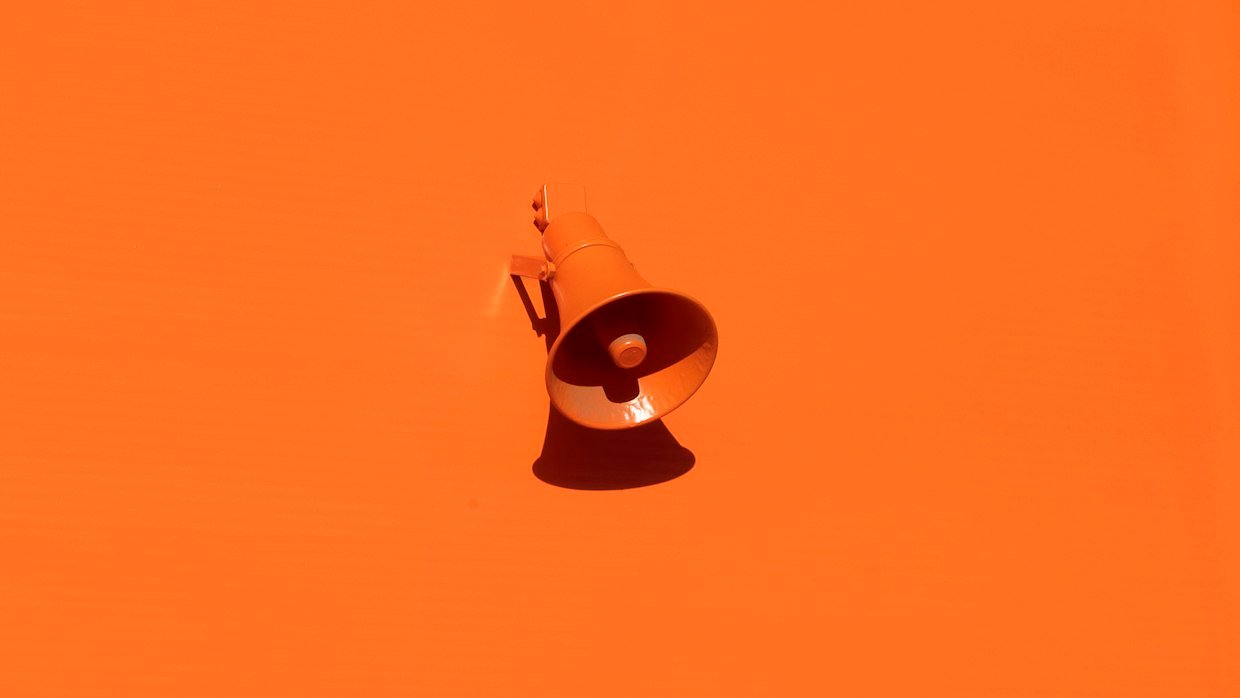A megaphone in front of a plain wall.