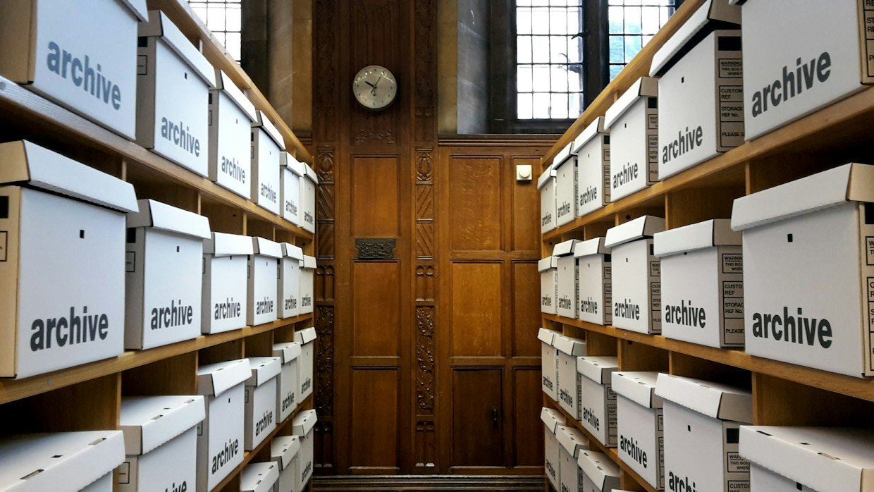 Archive boxes stacked in rows on shelving.