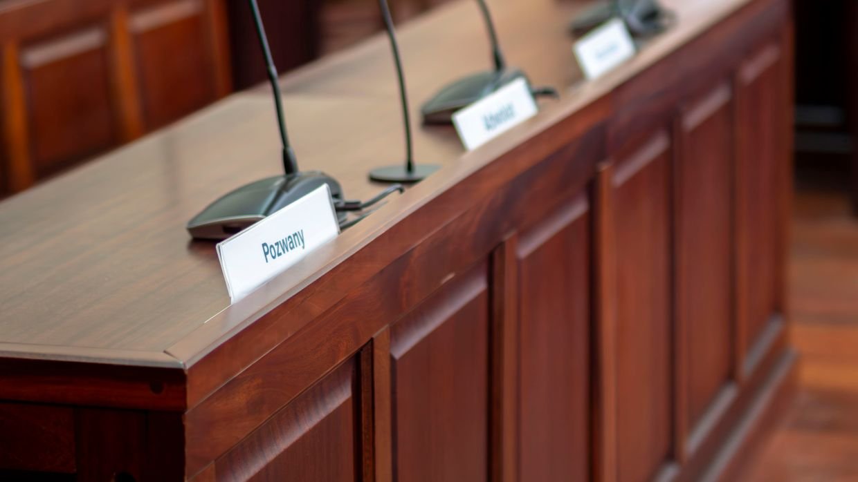 Several microphones lined up on a panel table.