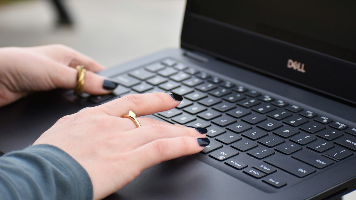 A finger on a laptop trackpad, selecting a button in the browser toolbar.