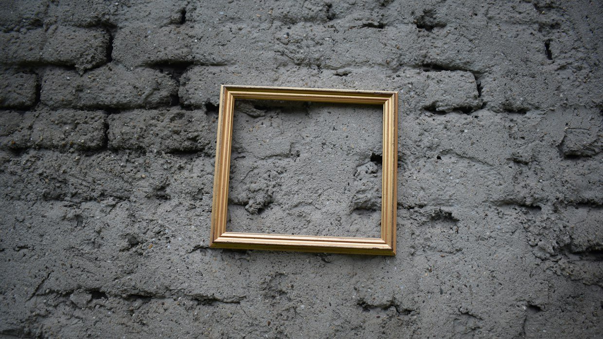 An empty picture frame hanging on a wall.