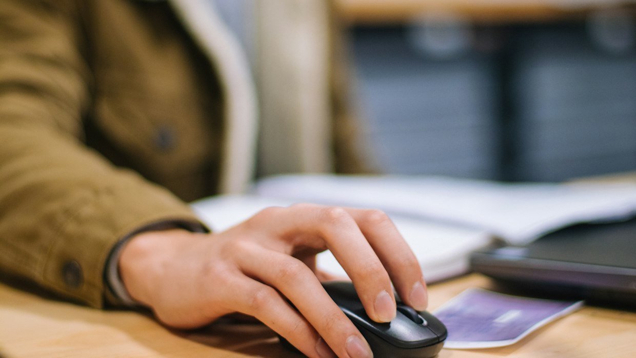 A hand resting on a computer mouse.