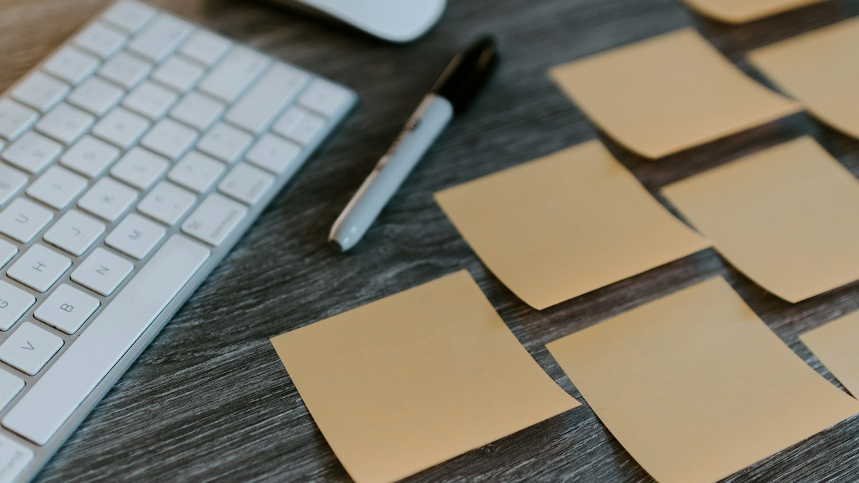 Sticky notes with written questions on a desk, like cue questions for later recall.