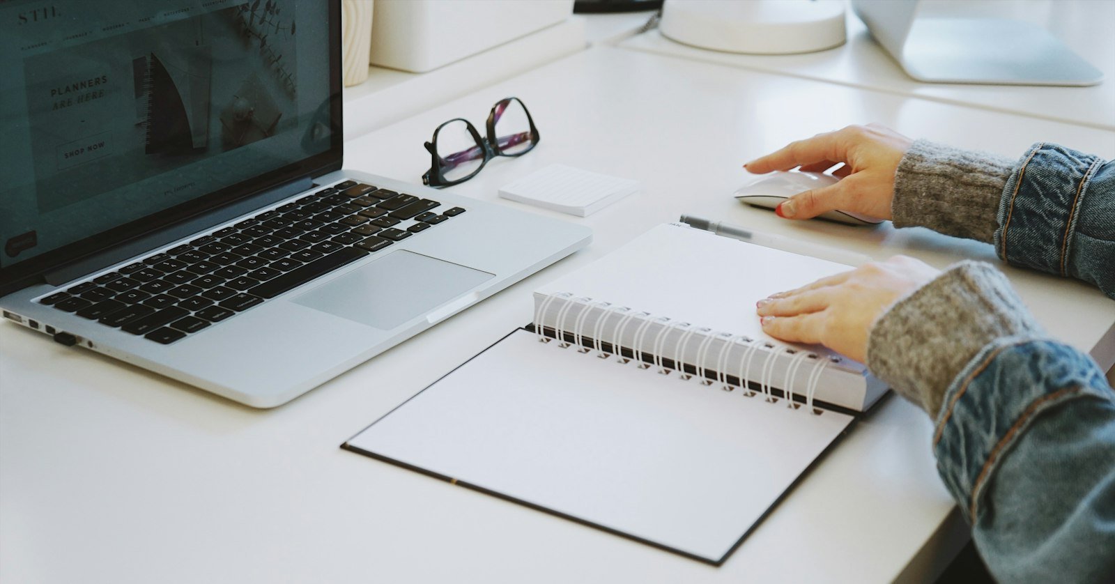 An open notebook with handwritten notes beside a laptop, for taking Cornell notes from a video.