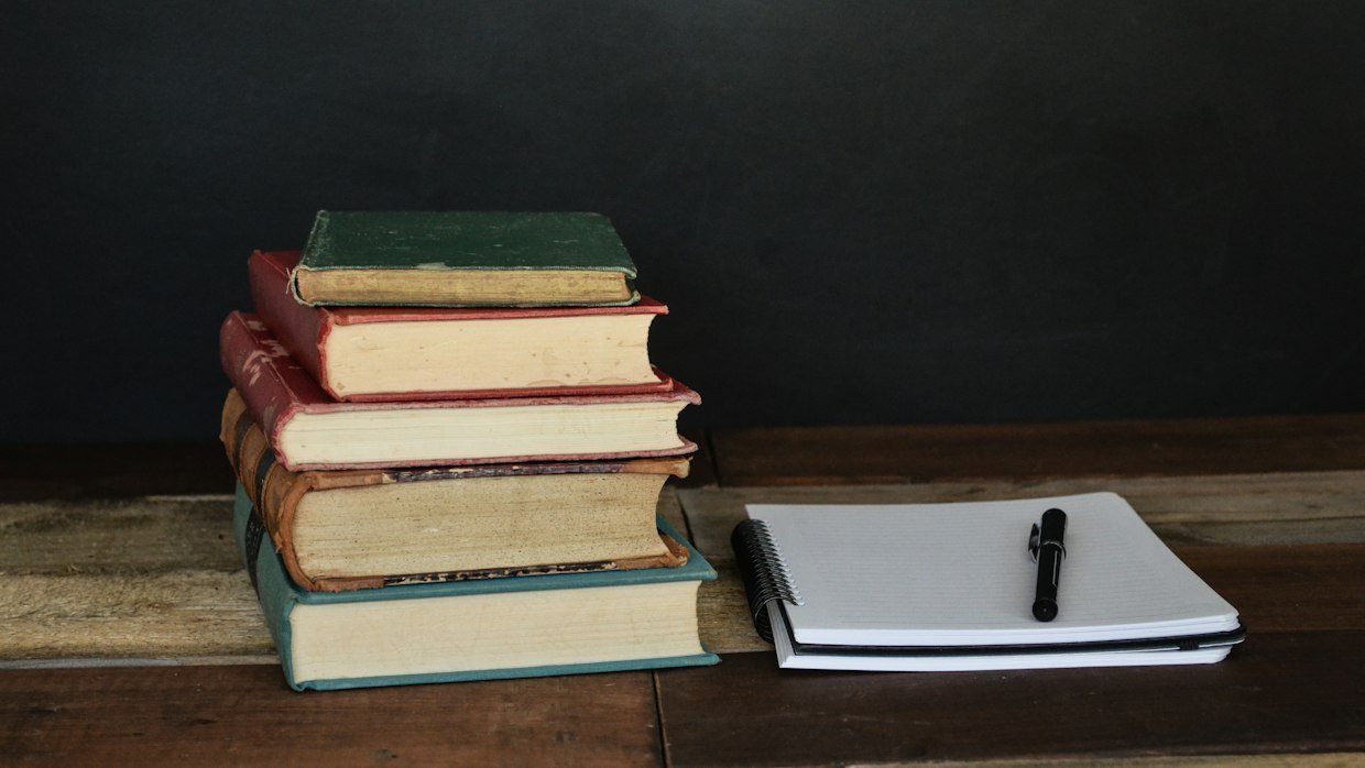 A stack of notebooks on a desk, for the weekly review of past Cornell pages.
