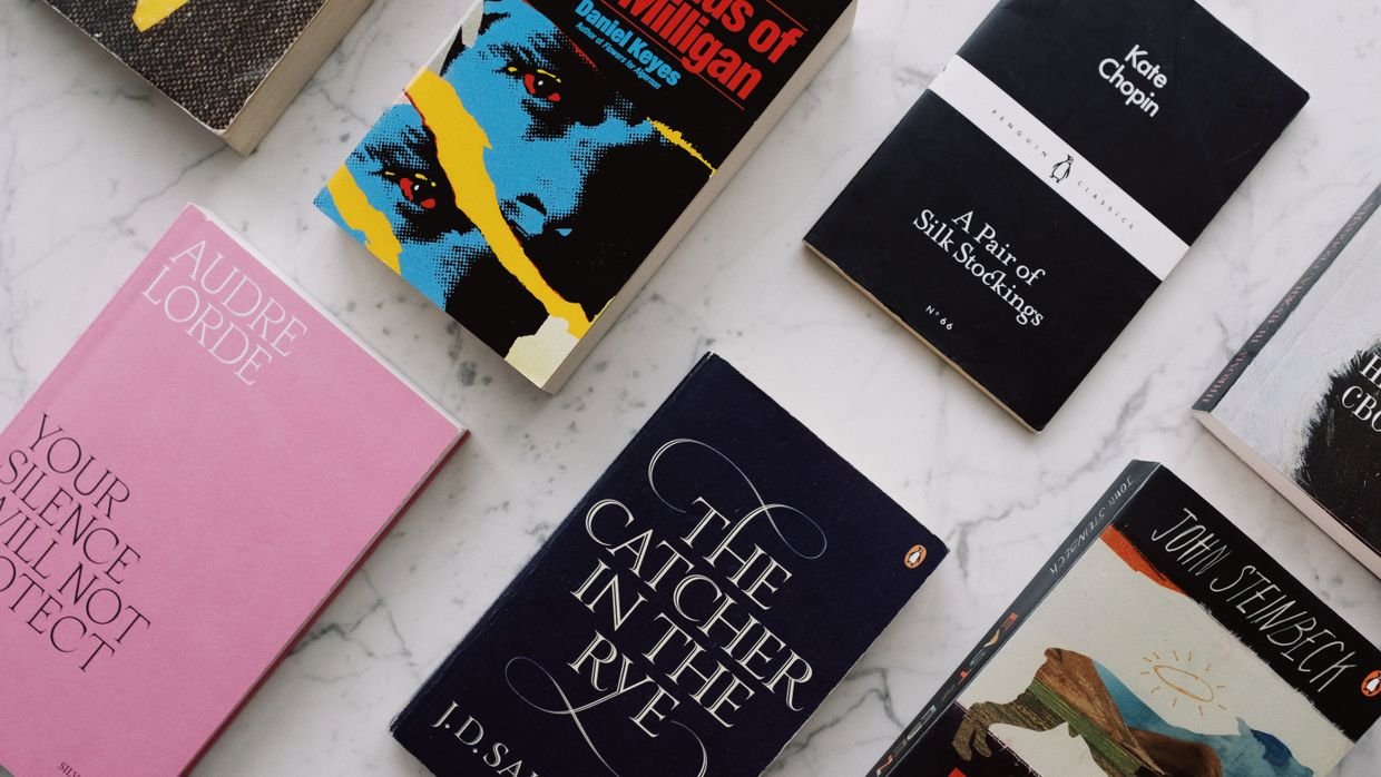 Many open books spread across a large table.