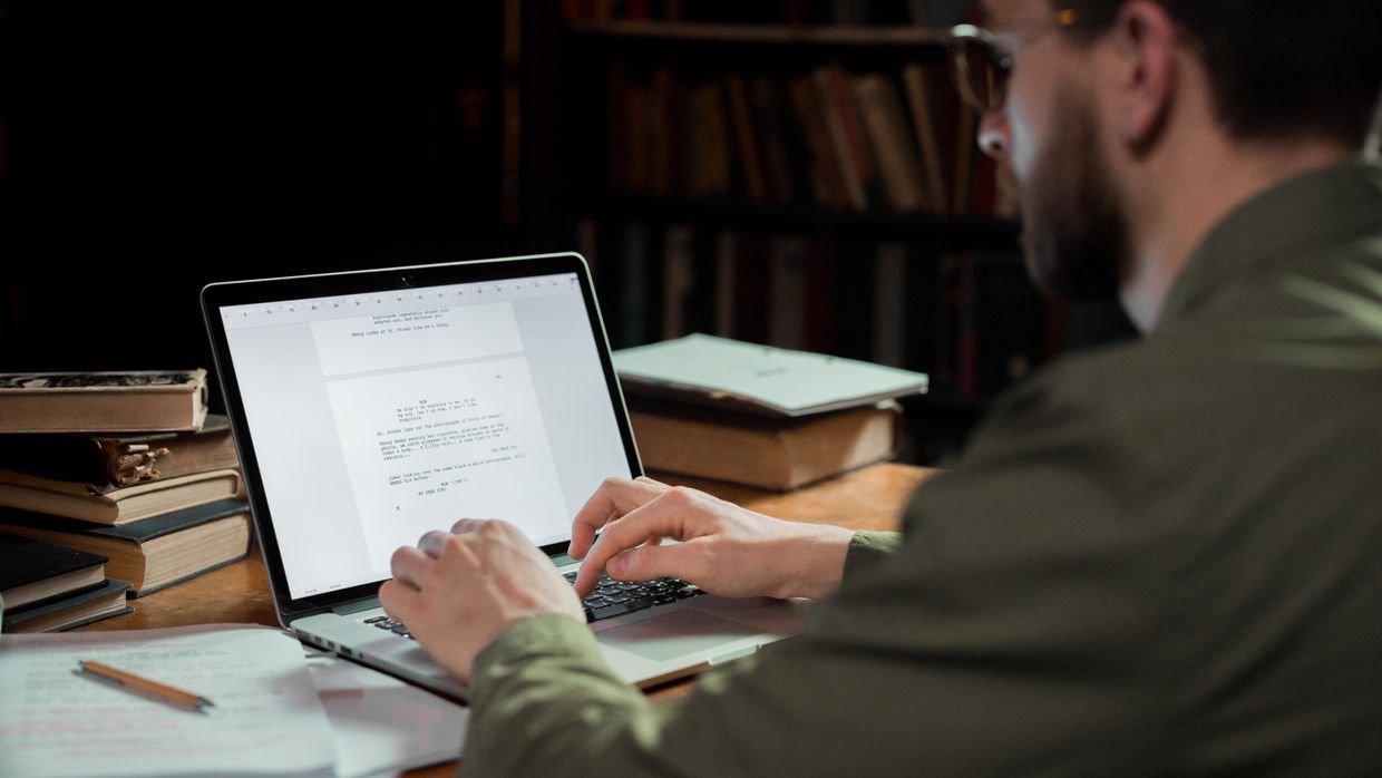 Someone checking sources at a desk, the fact-checking work a summary does not do.