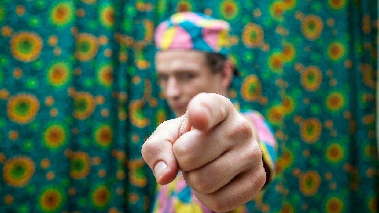 Someone pointing at a screen while speaking.