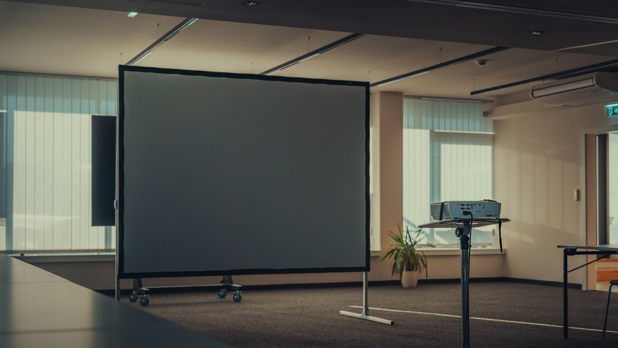 A blank cinema screen in an empty room.