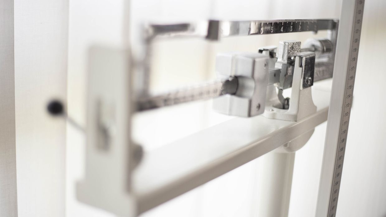 Balance scales holding small weights.