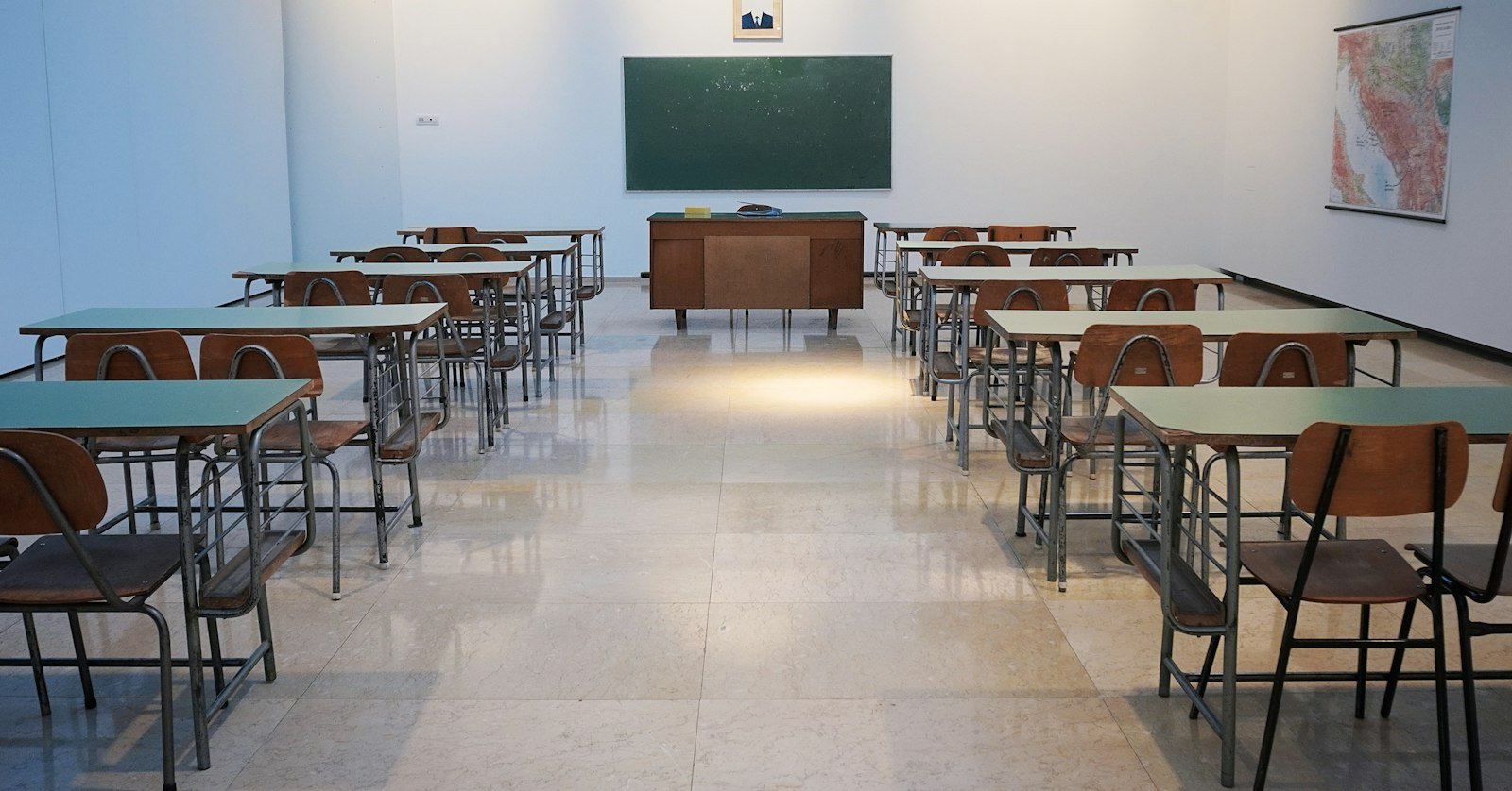 An empty classroom with a projector screen.