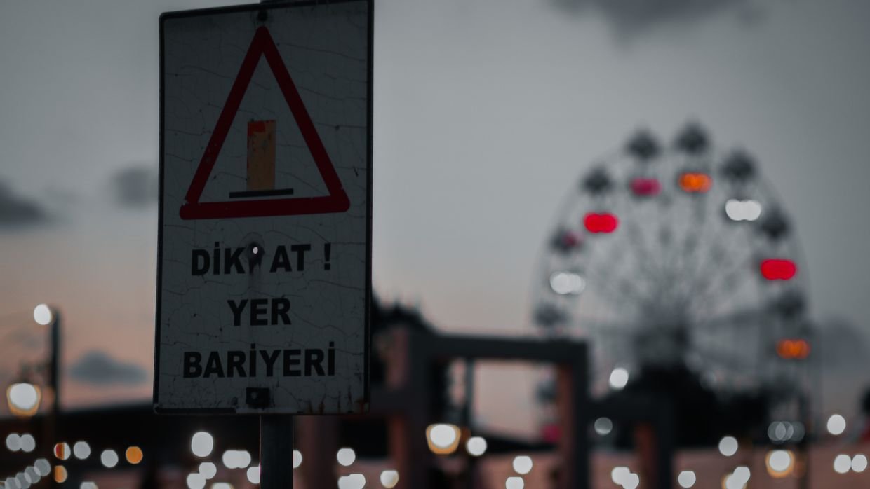 A blurred street sign at dusk.