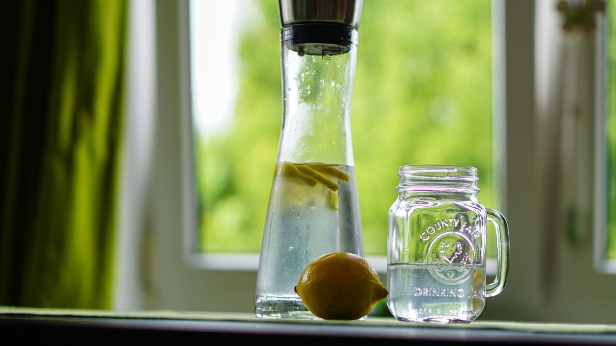 A clear glass of water on a windowsill.