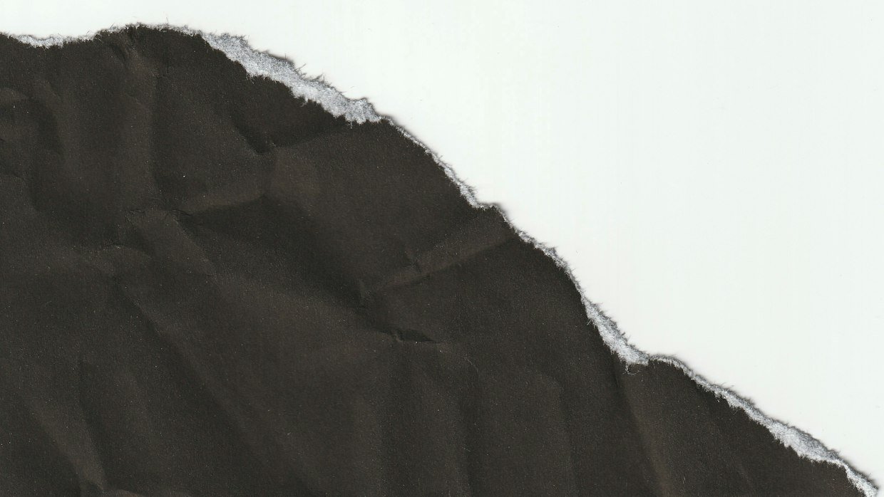 A torn sheet of paper with pieces missing.