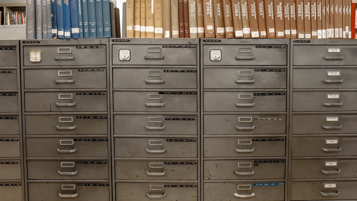 Open drawers in a shared filing cabinet.