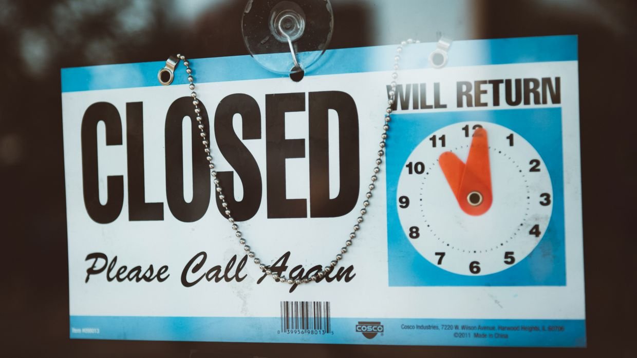 A closed sign hanging inside a glass door.