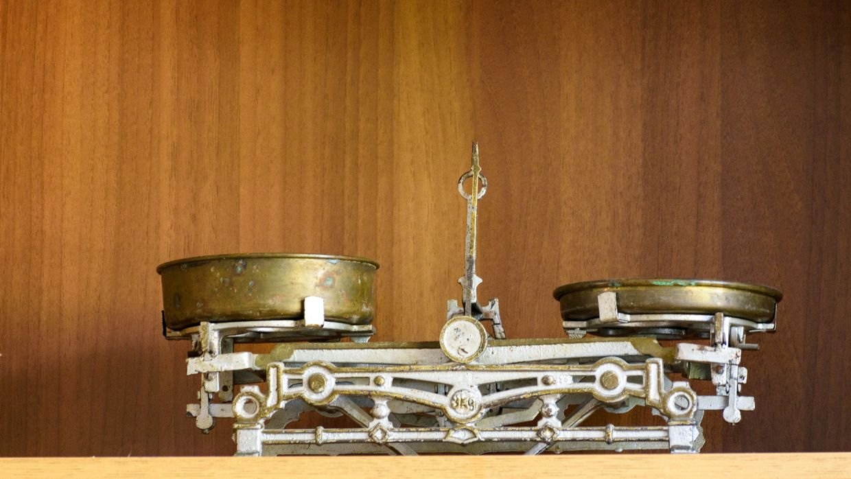 An old balance scale with empty pans.