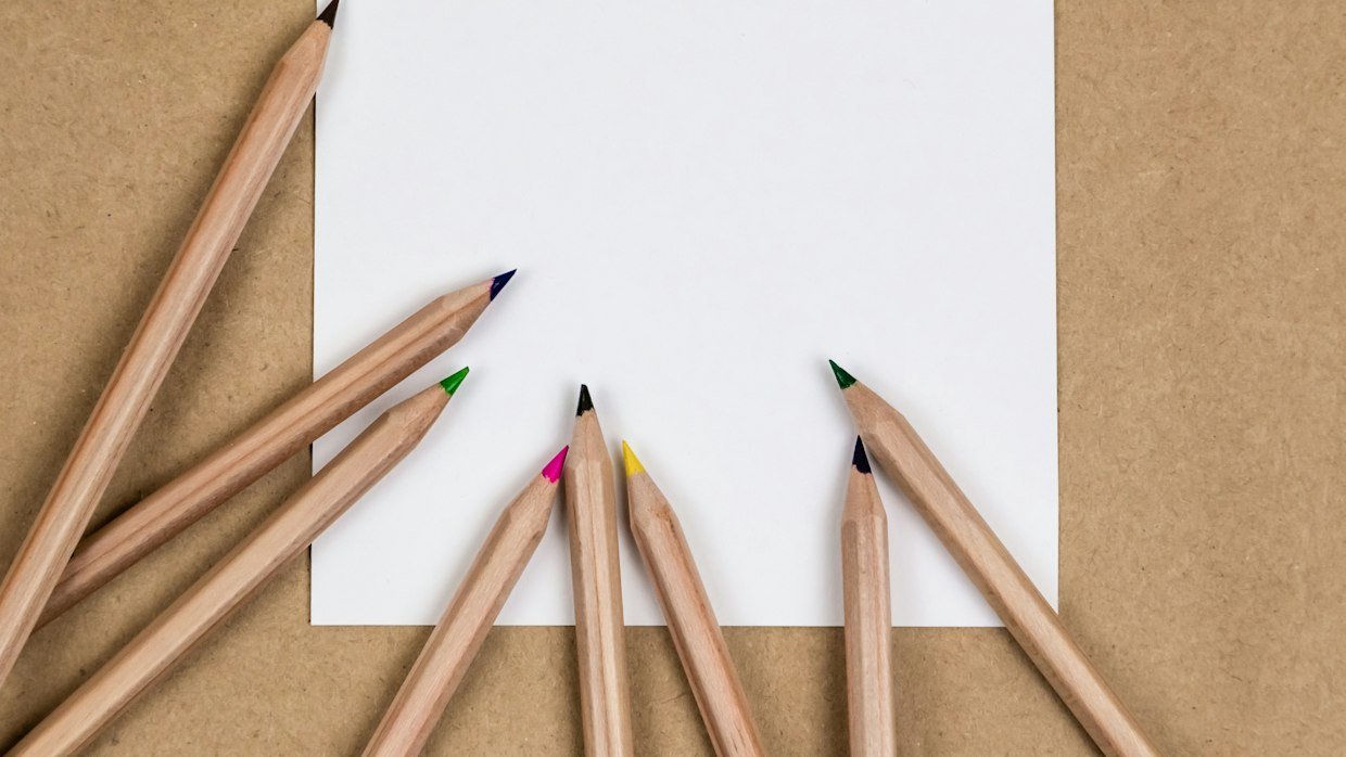 A ruler and pencil resting on blank paper.